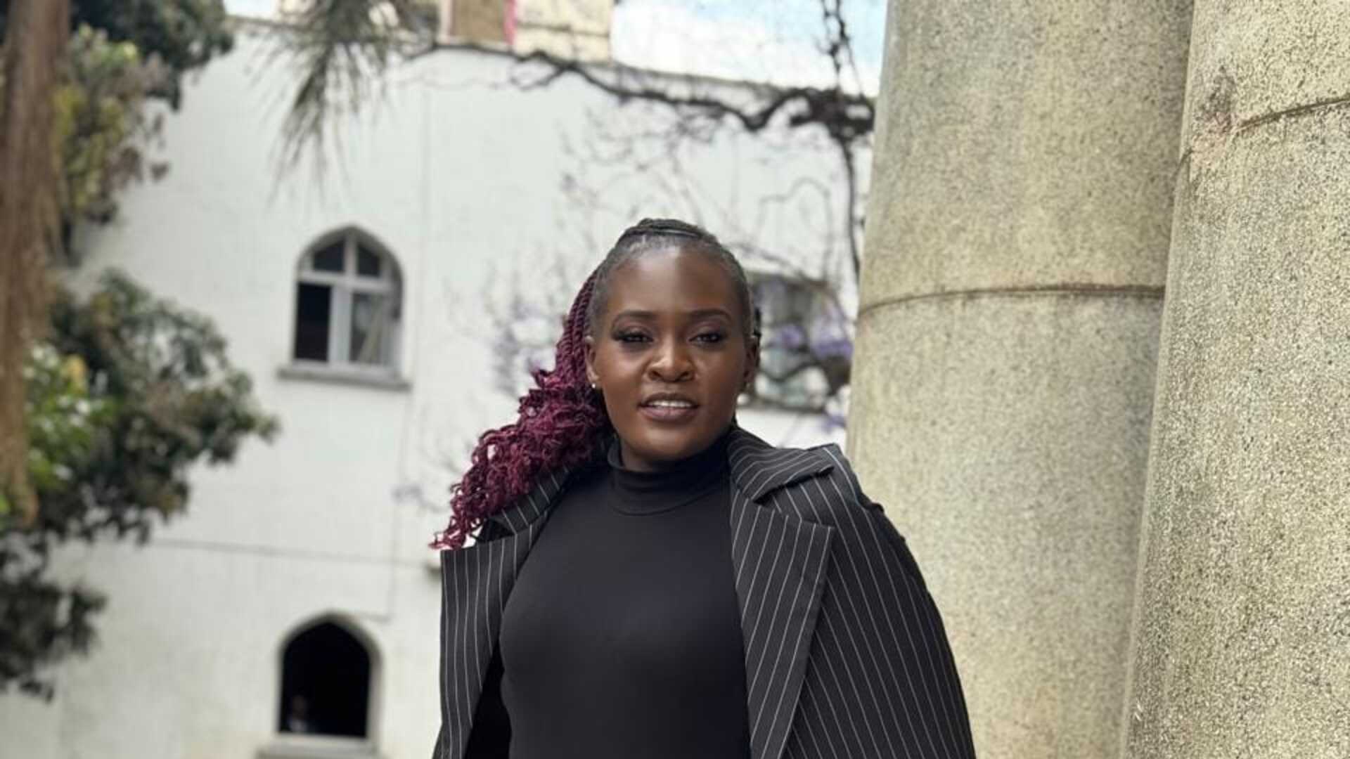 Model in a pinstripe suit near stone columns